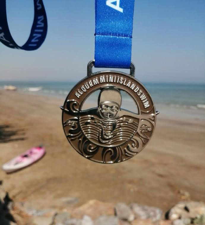 swim medal displayed at beach